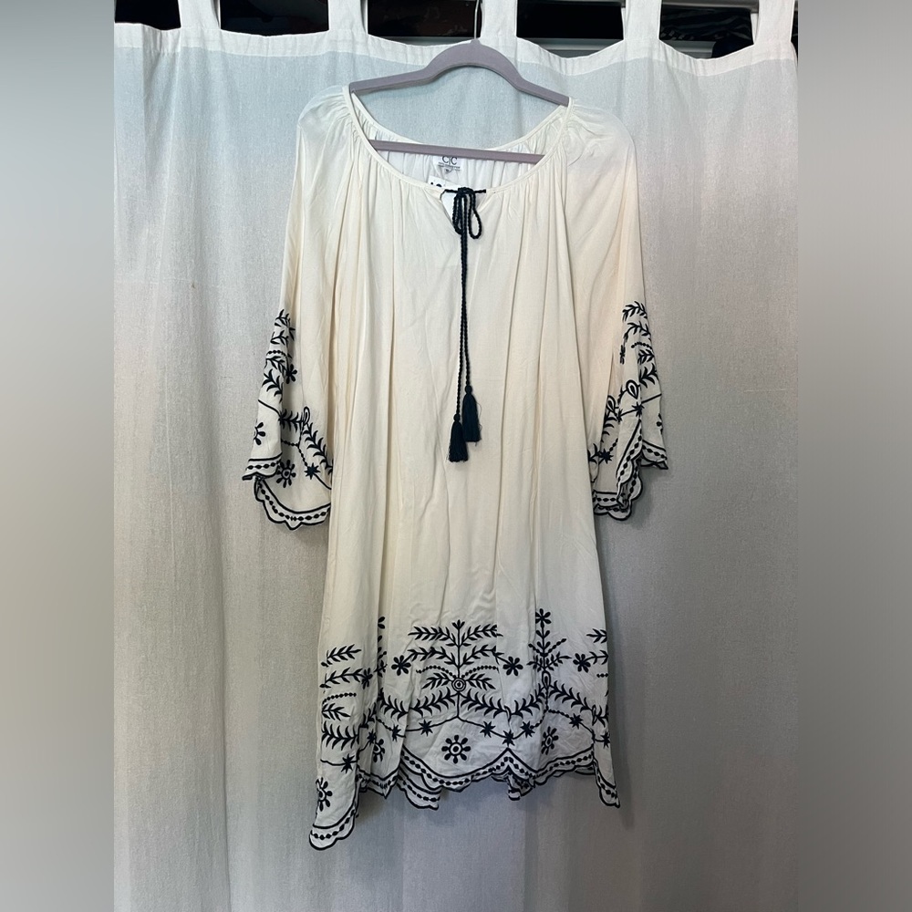 White knee length dress with blue floral design.